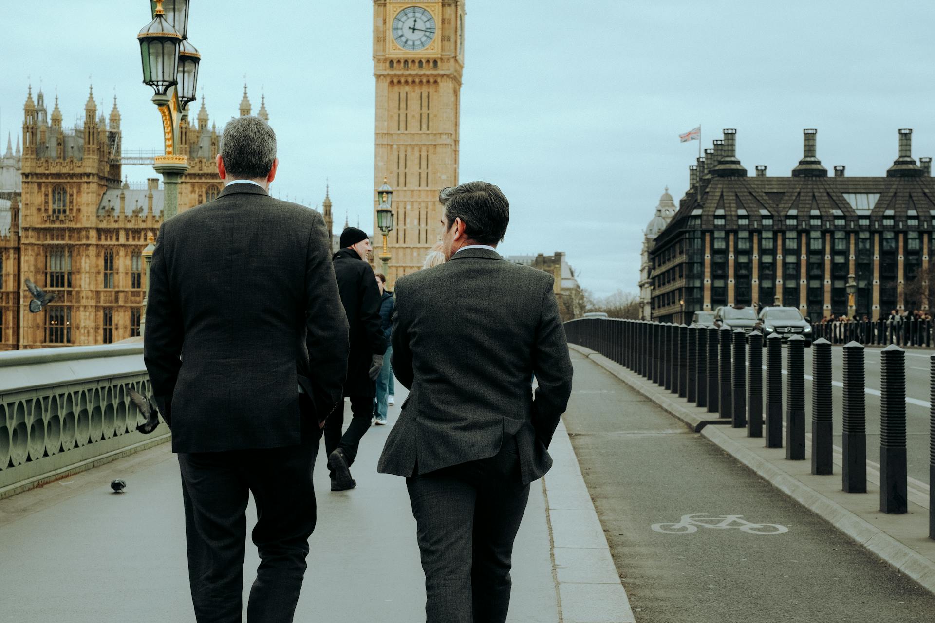 Elegant Men Walking on Pavement on Bridge